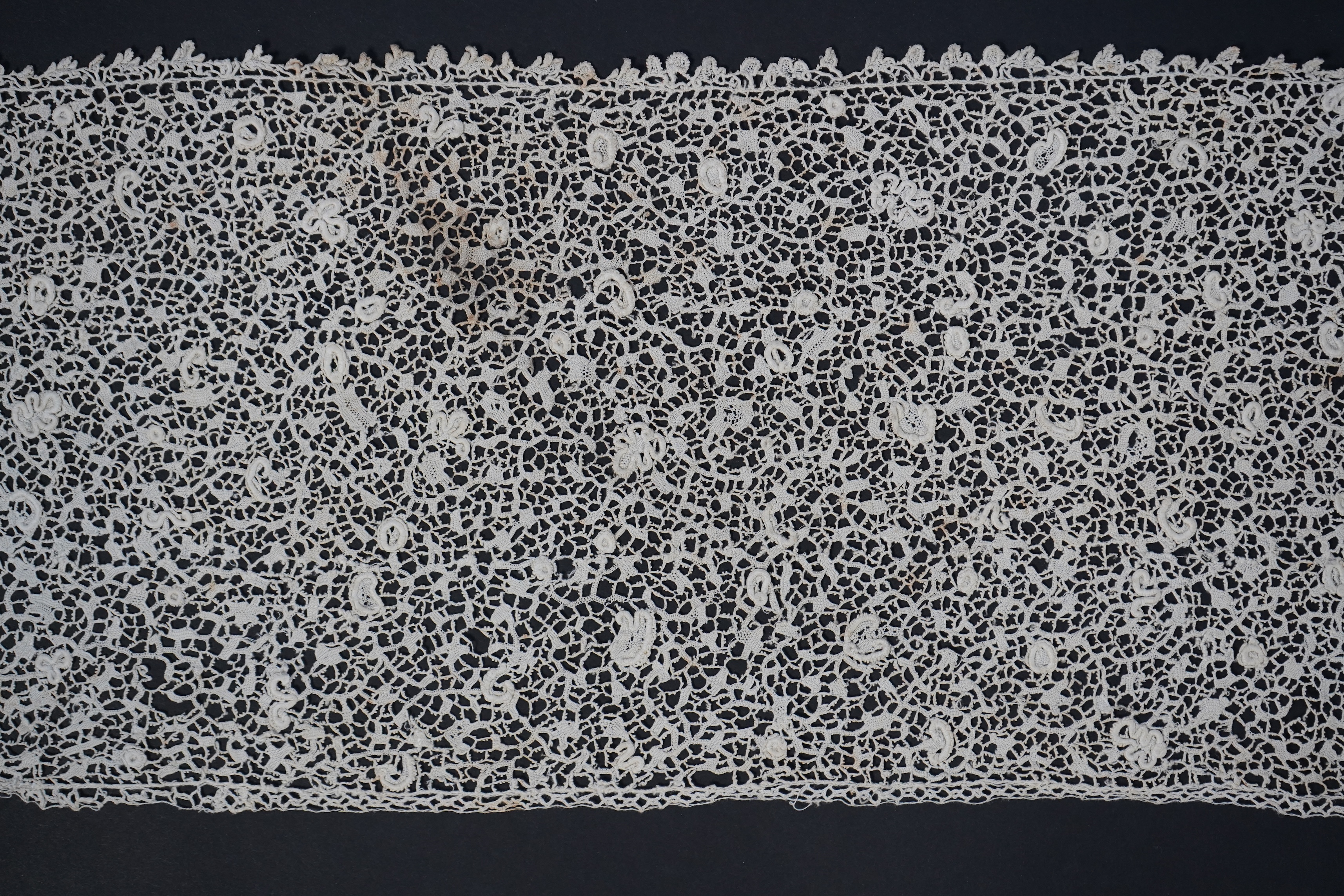 A late 17th century wide flounce of Point de France needle lace, together with a narrower flounce, both with raised elements of the design in the style of Point de Rose, but less so. This lace was very popular with the F